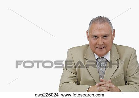 Portrait of a businessman sitting with his hands clasped View Large Photo Image Picture - Portrait of a businessman sitting with his hands clasped. Fotosearch