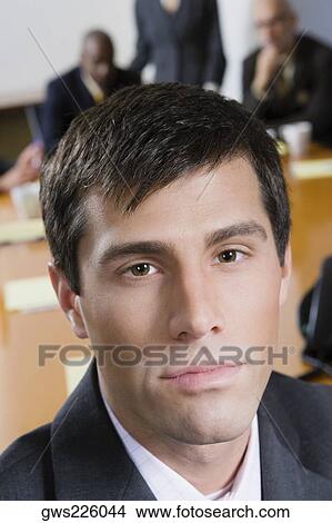 Portrait of a businessman with his colleagues in the background View Large Photo Image Picture - Portrait of a businessman with his colleagues in the background. Fotosearch