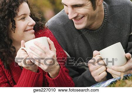 Stock Image - Close-up of a couple having coffee in a lawn. Fotosearch