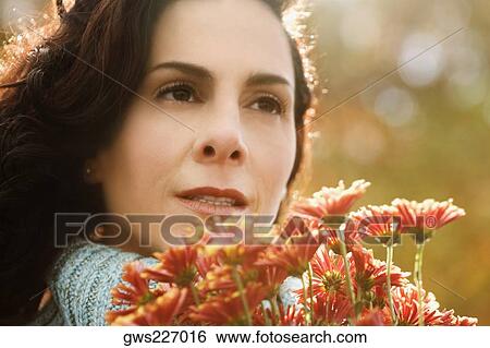 Stock Photograph - Close-up of a mature woman holding a bunch of flowers. Fotosearch