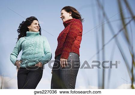 Low angle view of two mature women looking at each other and smiling View Large Photo Image Stock Photograph - Low angle view of two mature women looking at each other and smiling. Fotosearch