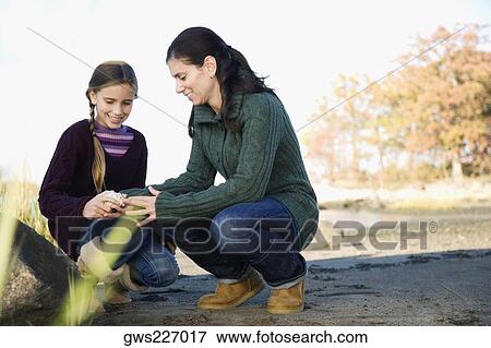 Mid adult woman examining her daughter View Large Photo Image Stock Photo - Mid adult woman examining her daughter. Fotosearch