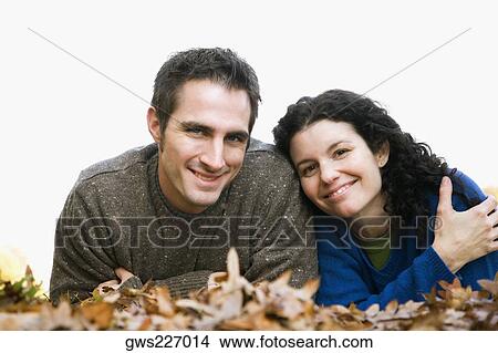 Portrait of a couple lying in a lawn View Large Photo Image Picture - Portrait of a couple lying in a lawn. Fotosearch