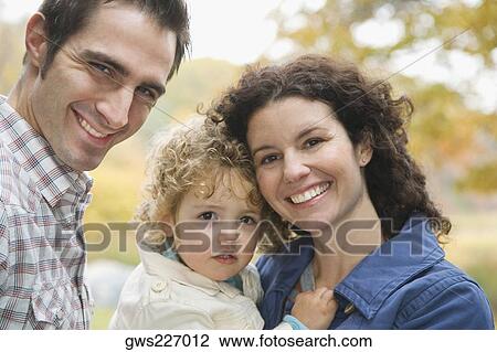 Portrait of a couple smiling with their daughter View Large Photo Image Stock Image - Portrait of a couple smiling with their daughter. Fotosearch