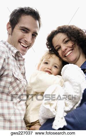 Stock Photo - Portrait of a couple smiling with their daughter. Fotosearch
