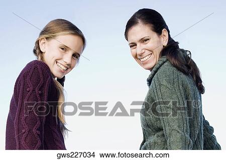 Portrait of a mid adult woman smiling with her daughter View Large Photo Image Picture - Portrait of a mid adult woman smiling with her daughter. Fotosearch
