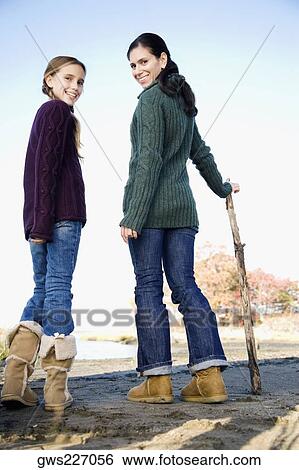 Portrait of a mid adult woman standing with her daughter and smiling View Large Photo Image Stock Photograph - Portrait of a mid adult woman standing with her daughter and smiling. Fotosearch