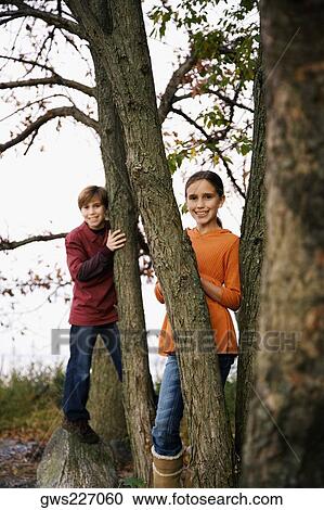 Portrait of two children playing in a forest View Large Photo Image Stock Image - Portrait of two children playing in a forest. Fotosearch