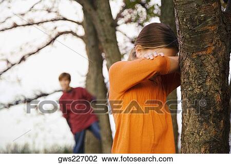 Two children playing hide and seek in the forest View Large Photo Image Stock Image - Two children playing hide and seek in the forest. Fotosearch