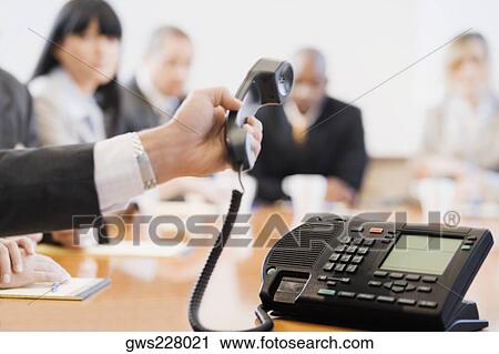 Close-up of a businessman's hand holding a conference phone receiver View Large Photo Image Stock Image - Close-up of a businessman's hand holding a conference phone receiver. Fotosearch
