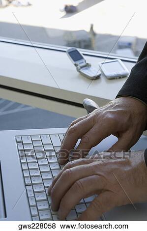 Close-up of a person's hands typing on a laptop in the waiting room of an airport View Large Photo Image Stock Photo - Close-up of a person's hands typing on a laptop in the waiting room of an airport. Fotosearch