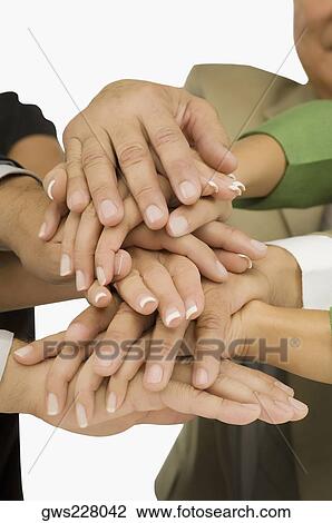 Stock Image - Close-up of business executives stacking hands. Fotosearch
