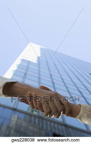 Low angle view of two people shaking hands View Large Photo Image Stock Photo - Low angle view of two people shaking hands. Fotosearch
