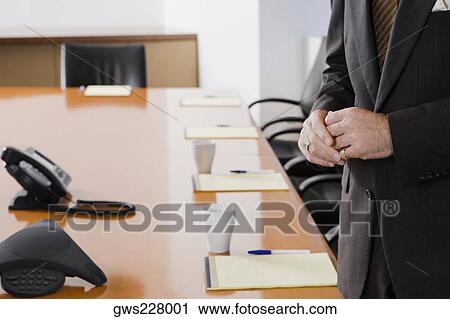 Mid section view of a businessman standing in a conference room View Large Photo Image Stock Image - Mid section view of a businessman standing in a conference room. Fotosearch