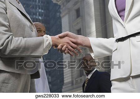 Mid section view of two businesswomen shaking hands View Large Photo Image Stock Image - Mid section view of two businesswomen shaking hands. Fotosearch