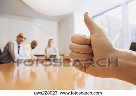 Stock Image - Person's hand showing thumbs up gesture. Fotosearch