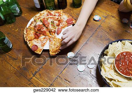 High angle view of a person's hand picking up a pizza slice View Large Photo Image Stock Image - High angle view of a person's hand picking up a pizza slice. Fotosearch