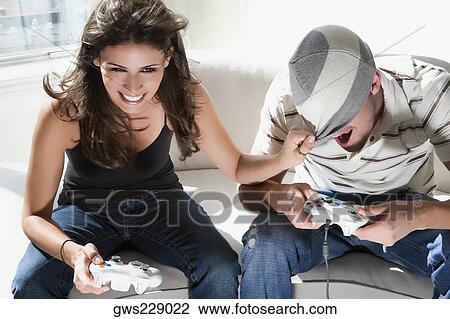 Stock Image - High angle view of a young couple playing video game. Fotosearch