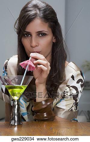 Portrait of a young woman drinking cocktail View Large Photo Image Picture - Portrait of a young woman drinking cocktail. Fotosearch
