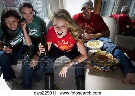 Two young couples sitting on a couch and drinking beer View Large Photo Image Stock Image - Two young couples sitting on a couch and drinking beer. Fotosearch