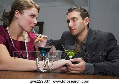 Young couple drinking cocktail and romancing View Large Photo Image Stock Photo - Young couple drinking cocktail and romancing. Fotosearch