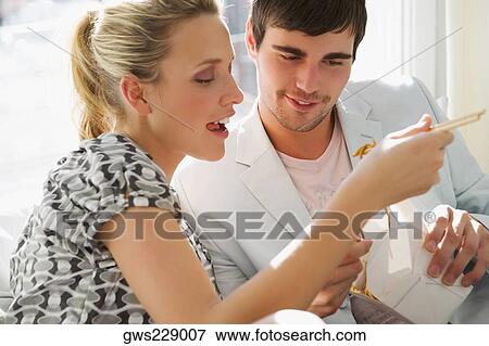 Young couple having food View Large Photo Image Stock Photo - Young couple having food. Fotosearch