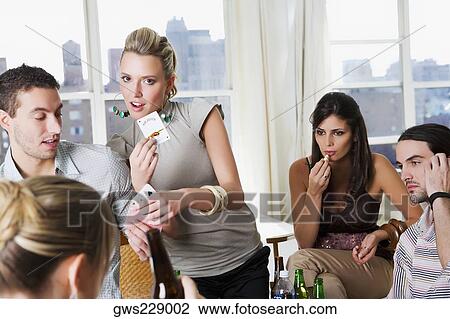 Young man and a young woman playing cards with their friends View Large Photo Image Stock Image - Young man and a young woman playing cards with their friends. Fotosearch
