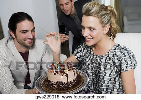 Stock Photo - Young woman celebrating birthday with her friends. Fotosearch