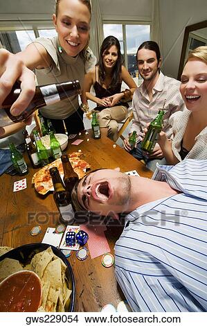 Picture - Young woman with her friends enjoying a party. Fotosearch