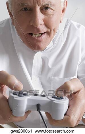 Close-up of a senior man playing a video game View Large Photo Image Stock Image - Close-up of a senior man playing a video game. Fotosearch