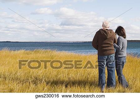 Couple standing on the beach View Large Photo Image Stock Photograph - Couple standing on the beach. Fotosearch