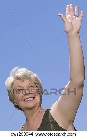 Low angle view of a senior woman waving her hand View Large Photo Image Picture - Low angle view of a senior woman waving her hand. Fotosearch