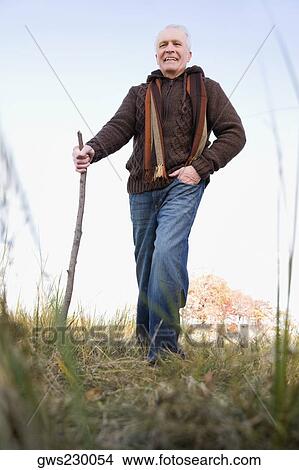 Senior man hiking in a field View Large Photo Image Picture - Senior man hiking in a field. Fotosearch