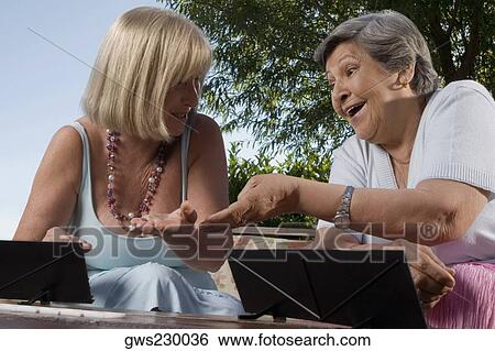 Two senior women playing games and smiling View Large Photo Image Stock Photograph - Two senior women playing games and smiling. Fotosearch