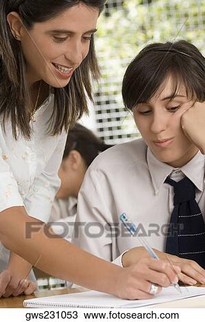 Close-up of a female teacher teaching a teenage girl in a classroom View Large Photo Image Stock Image - Close-up of a female teacher teaching a teenage girl in a classroom. Fotosearch
