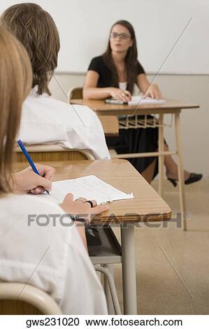 Female teacher with teenage students in the classroom View Large Photo Image Stock Image - Female teacher with teenage students in the classroom. Fotosearch