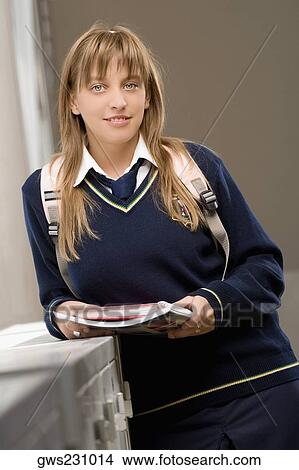 Portrait of a teenage girl holding notebooks and smiling View Large Photo Image Picture - Portrait of a teenage girl holding notebooks and smiling. Fotosearch