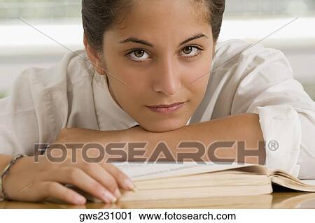 Portrait of a teenage girl leaning on a textbook View Large Photo Image Stock Image - Portrait of a teenage girl leaning on a textbook. Fotosearch