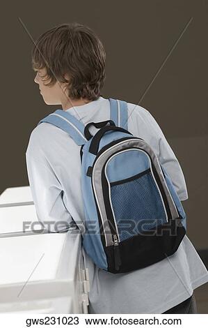 Rear view of a teenage boy carrying a backpack View Large Photo Image Stock Image - Rear view of a teenage boy carrying a backpack. Fotosearch