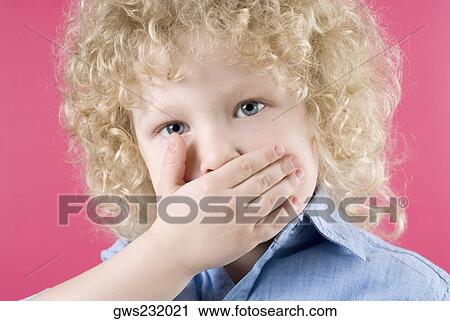 Close-up of a boy covering his mouth with his hands View Large Photo Image Stock Image - Close-up of a boy covering his mouth with his hands. Fotosearch
