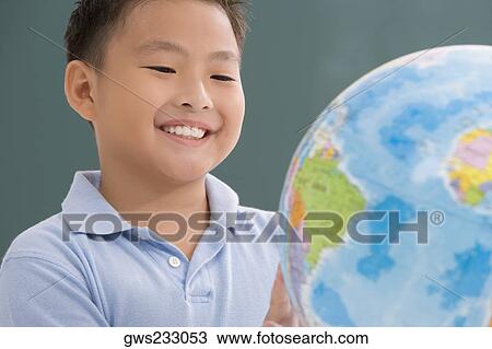 Close-up of a schoolboy looking at a globe in a classroom View Large Photo Image Stock Image - Close-up of a schoolboy looking at a globe in a classroom. Fotosearch