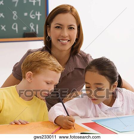 Stock Image - Female teacher teaching her two students. Fotosearch