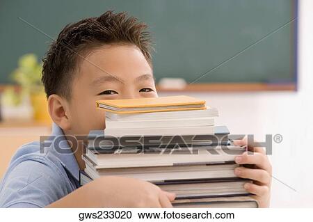 Portrait of a schoolboy holding a stack of books View Large Photo Image Stock Image - Portrait of a schoolboy holding a stack of books. Fotosearch