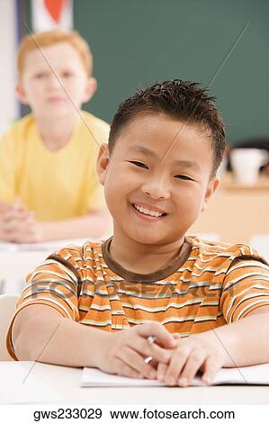 Portrait of a schoolboy smiling in a classroom View Large Photo Image Stock Photo - Portrait of a schoolboy smiling in a classroom. Fotosearch