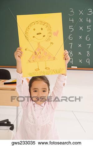 Portrait of a schoolgirl showing her drawing and smiling View Large Photo Image Stock Photography - Portrait of a schoolgirl showing her drawing and smiling. Fotosearch