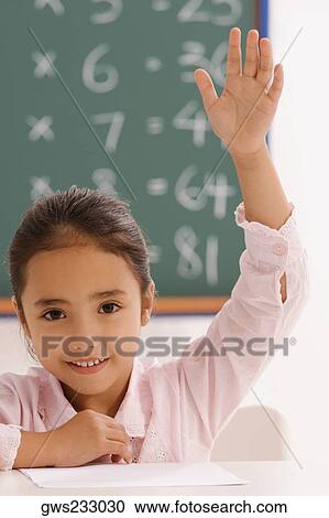 Portrait of a schoolgirl with her hand raised in a classroom View Large Photo Image Stock Image - Portrait of a schoolgirl with her hand raised in a classroom. Fotosearch