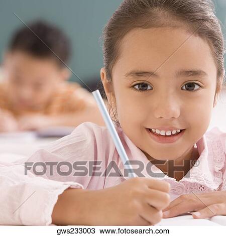 Portrait of a schoolgirl writing on a notebook with a pencil and smiling View Large Photo Image Stock Image - Portrait of a schoolgirl writing on a notebook with a pencil and smiling. Fotosearch