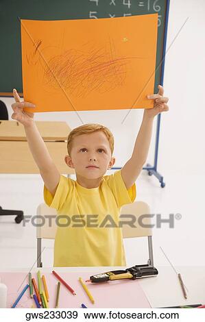 Stock Photo - Schoolboy showing his drawing. Fotosearch