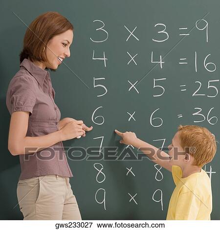 Side profile of a female teacher teaching her student on a blackboard View Large Photo Image Stock Photo - Side profile of a female teacher teaching her student on a blackboard. Fotosearch