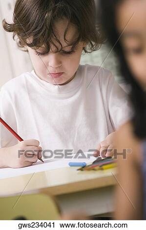 Close-up of a boy drawing on a sheet of paper View Large Photo Image Stock Image - Close-up of a boy drawing on a sheet of paper. Fotosearch